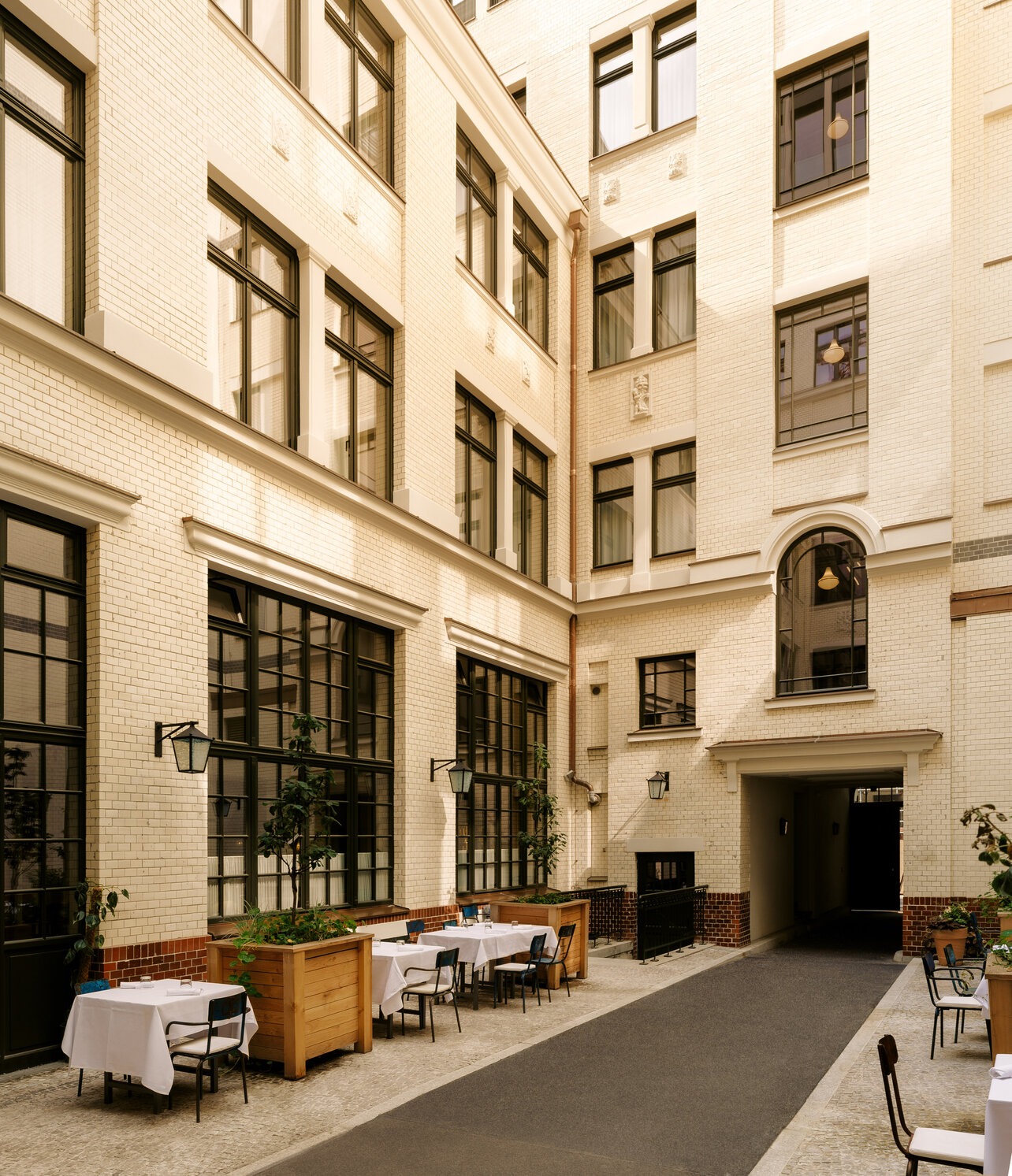 View of the charming historic inner courtyard of the Château Royal restaurant in Berlin Mitte with elegant white table settings
